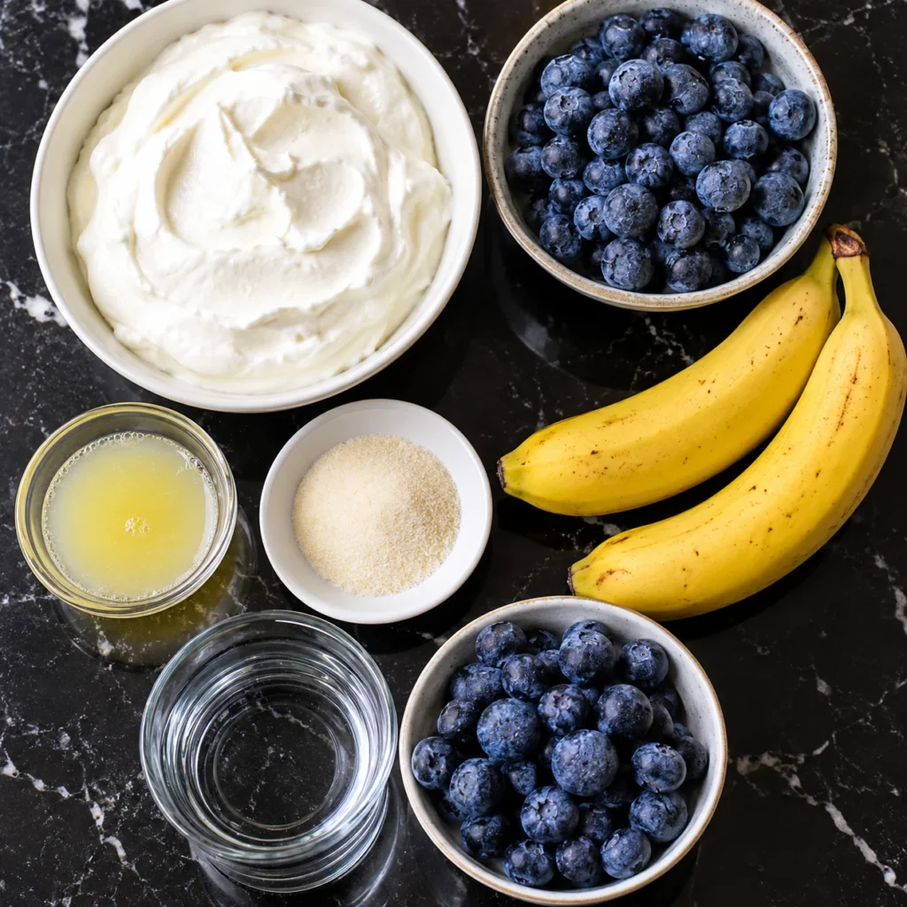 Cheesecake de Arándanos Cremoso sin Horno: Receta Ligera con Yogur Griego 2 Ingredientes para cheesecake de arándanos cremoso sin horno con yogur griego, plátanos, arándanos frescos, limón y gelatina.